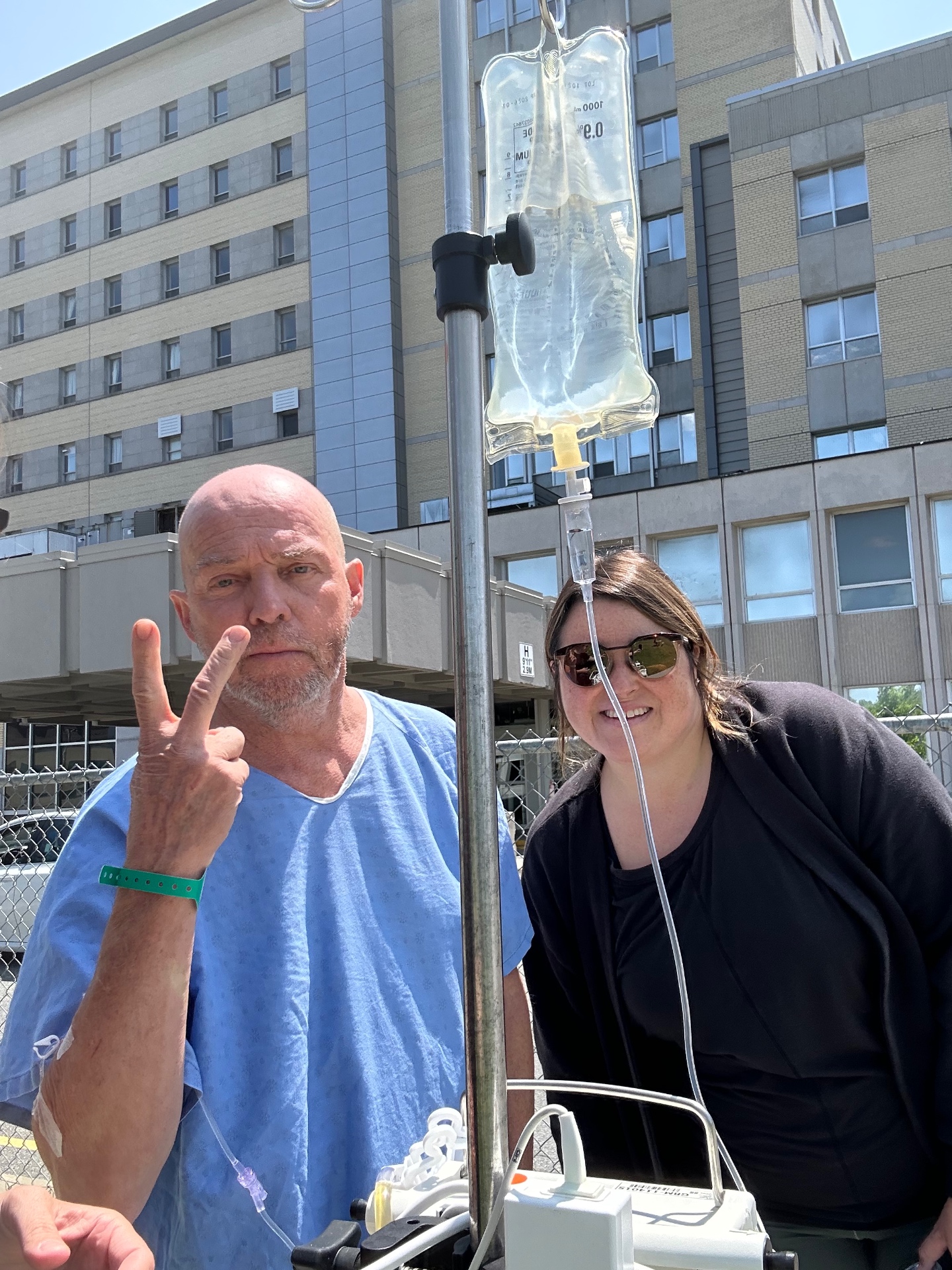 Ma sœur aux côtés de notre père, avec son soluté, lors d'une sortie durant son hospitalisation